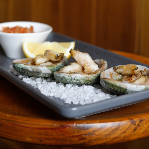 Prepared Tasmanian abalone served on a plate with lemon.